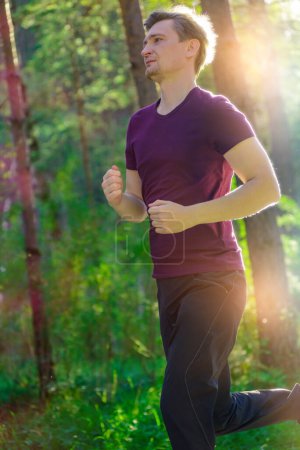 Foto de Hombre corriendo corriendo corriendo en el parque de la ciudad en un hermoso día de verano. Deporte fitness modelo caucásico etnia entrenamiento al aire libre. - Imagen libre de derechos