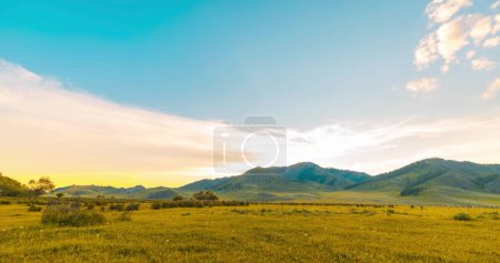 Photo for Mountain meadow time-lapse at the summer or autumn sunrise. Wild nature and rural field. Clouds movement, green grass and sun rays. Motorised panorama - Royalty Free Image