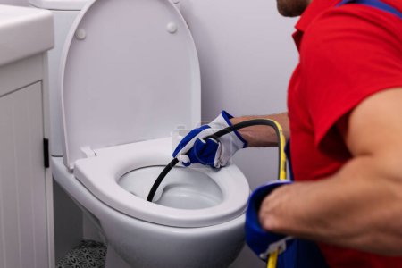 Klempner unclocking blockierte Toilette mit Hydro-Jet zu Hause Badezimmer. Kanalreinigung