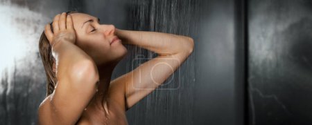 Téléchargez les photos : Femme prenant une douche. debout sous l'eau courante et laver les cheveux et le corps. bannière avec espace de copie - en image libre de droit