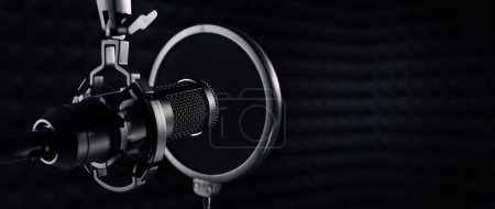 Foto de Microphone in dark sound recording studio. banner with copy space - Imagen libre de derechos