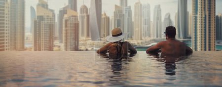 Foto de Pareja disfrutando de vista panorámica del puerto deportivo de Dubai desde la piscina infinita. Viajes a los EAU. espacio de copia de banner - Imagen libre de derechos