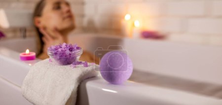 Foto de Mujer disfrutando de la bañera con cristales de sal marina y bomba de baño. spa en casa. banner con espacio de copia - Imagen libre de derechos