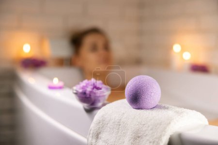 Foto de Spa en casa. mujer relajante en la bañera en la luz de la vela y el uso de la bomba de baño y cristales de sal marina para la piel corporal hidratante - Imagen libre de derechos