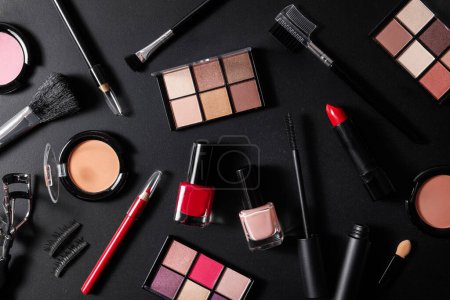 Foto de Cosméticos maquillaje conjunto sobre fondo negro. colección de productos de belleza. vista superior - Imagen libre de derechos