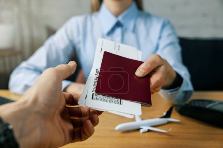 Foto de Agente de viajes dar billetes de avión y pasaporte al cliente en la oficina de la agencia. servicio de planificación de vacaciones - Imagen libre de derechos
