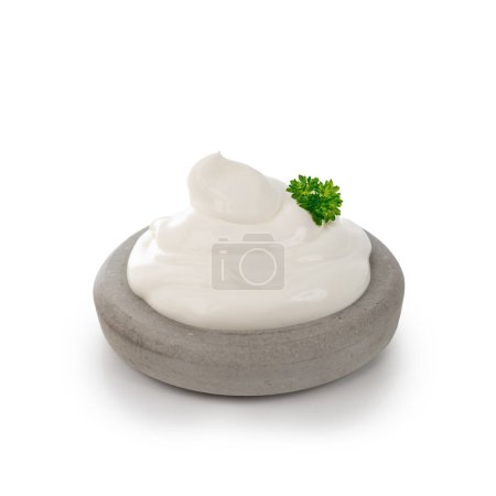 Foto de Crema agria con hierba sobre placa de piedra aislada sobre fondo blanco - Imagen libre de derechos