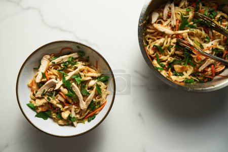 Photo for Healthy Thai chicken noodle salad. Aisan cuisine. Fresh and cold boiled rice noodles with chicken and vegetables and sauce based on soy, fish and sweet chilli sauce with garlic and ginger. Top view - Royalty Free Image