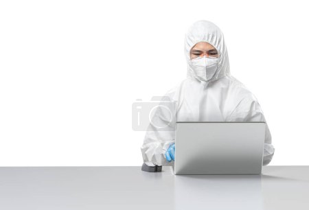 Téléchargez les photos : Worker wears medical protective suit or white coverall suit with mask and goggles with computer notebook isolated on white background - en image libre de droit