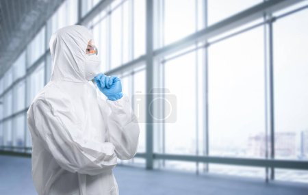 Téléchargez les photos : Worker wears medical protective suit or white coverall suit with mask and goggles analyze - en image libre de droit