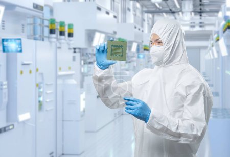 Foto de Trabajador o ingeniero usa traje de protección médica o traje de mono blanco con chipset en fábrica de semiconductores - Imagen libre de derechos
