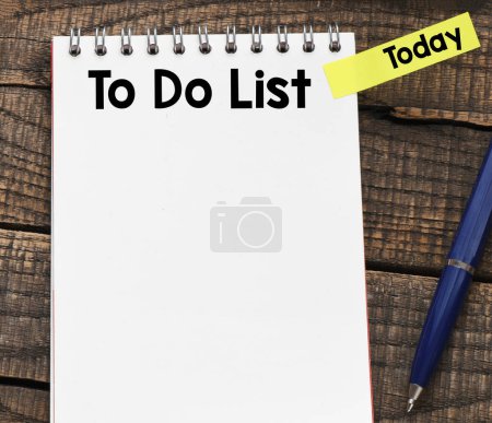Téléchargez les photos : Pour faire la liste dans un carnet de bureau sur un fond en bois. - en image libre de droit