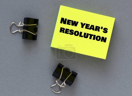 Photo for New year's resolution words on a small piece of paper. - Royalty Free Image