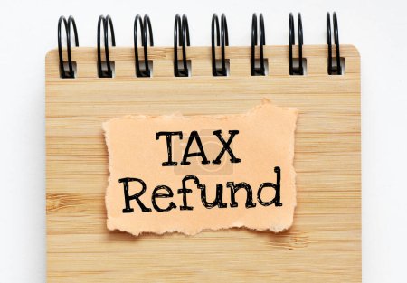 TAX REFUND words written on a piece of paper. Concept for business.