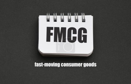Foto de FMCG palabras de bienes de consumo en movimiento rápido sobre un pequeño pedazo de papel y un fondo negro. - Imagen libre de derechos