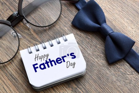 Photo for Happy Father's Day text on notepad on wooden background. Greetings and presents - Royalty Free Image
