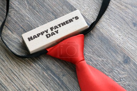 Photo for Happy Father's Day text on black piece of paper on wooden background. Greetings and presents - Royalty Free Image