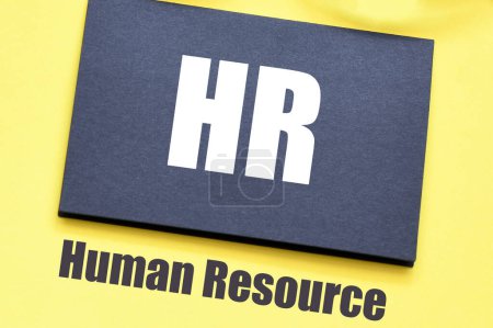 Photo for HR - Human Resource words on a black piece of paper and a yellow background. - Royalty Free Image