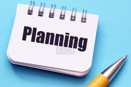 Téléchargez les photos : Le mot Planification dans un carnet sur une table bleue. - en image libre de droit