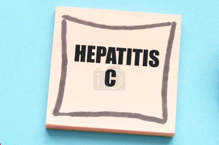 Konzept der HEPATITIS C Wörter in einem Büroheft neben einem Stethoskop und einem Herz.