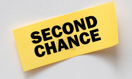 SECOND CHANCE words on a small yellow sheet of paper laid on a notebook.