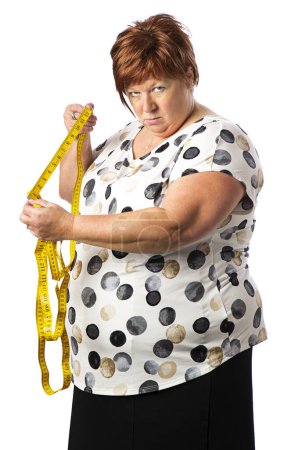 Photo for Isolated fifty year old woman, holding a yellow mesuring tape and long length with angry expression - Royalty Free Image