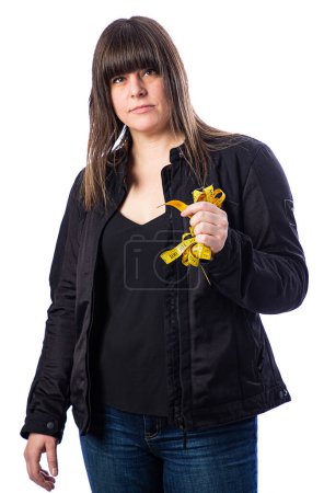 Photo for Forty year old woman, wearing  a motocycle jacket, holding a yellow mesuring tape, isolated on a white backgroind - Royalty Free Image