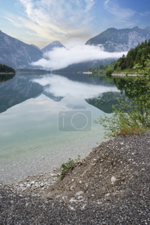 Lake Plansee in Austria Tirol in the evening with fog.