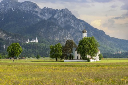 Beautiful view of the Saint Coloman church near the Neuschwanstein castle, against the backdrop of the beautiful mountains, Schwangau in the Bavarian province of Germany