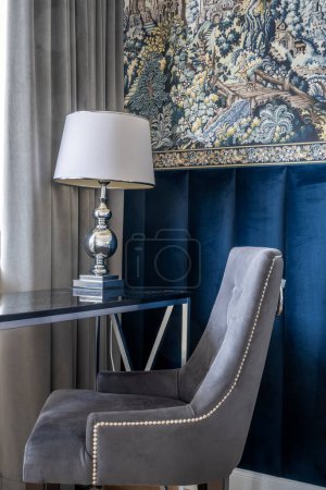 Téléchargez les photos : Fauteuil et lampe coin table dans une chambre élégante avec papier peint décoratif et mur de velours - en image libre de droit