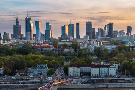 Téléchargez les photos : Warszawa, Pologne - 9 avril 2024 : La vue panoramique du centre-ville de Varsovie offre un mélange vibrant de monuments et de gratte-ciel modernes, encadrés par la forme moderne du pont piétonnier et cyclable nouvellement ouvert en avril. - en image libre de droit