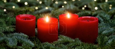 Photo for Red Advent candles, two burning, with fir branches and bokeh lights. The image is part of a set. - Royalty Free Image
