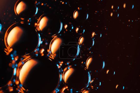 Téléchargez les photos : Microbulles dans l'eau et le fond d'huile, jaune abstrait coloré - lumières LED vertes, super-macro abstraction, fond noir - en image libre de droit