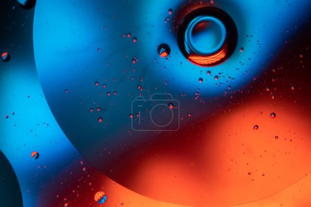 Téléchargez les photos : Mélange d'eau et d'huile, fond abstrait coloré orange lumières led bleues, cercles et bulles, image macro abstraction - en image libre de droit