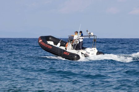 Foto de FIUMEFREDDO DI SICILIA, SICILIA, ITALIA - 12 de agosto de 2022 Guardacostas patrullando con un bote salvavidas cerca de la costa de Sicilia en el Mar Mediterráneo - Imagen libre de derechos