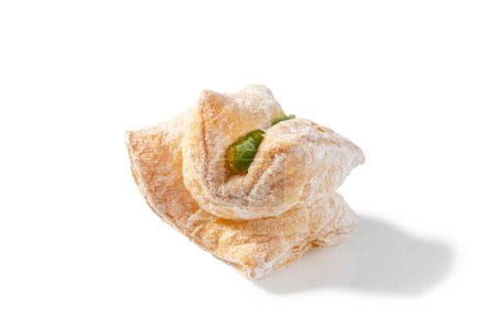 Foto de Una deliciosa golosina con hojaldre escamoso lleno de delicia turca verde y espolvoreado con un velo de azúcar en polvo - Imagen libre de derechos