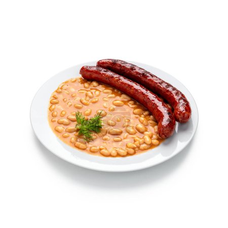 Photo for Indulge in the rustic charm of a hearty bean stew with succulent sausages, served elegantly on a pristine white plate. This comforting dish brings warmth and flavor to any dining experience - Royalty Free Image