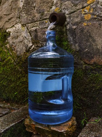 Photo for Bottle with fresh cold natural spring water from source - Royalty Free Image