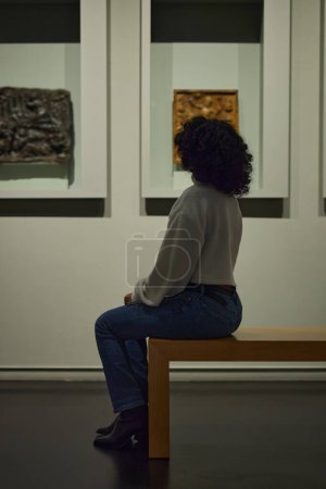 Photo for Woman visitor in the historical museum looking at pictures. - Royalty Free Image