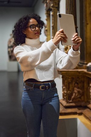 Photo for Woman visitor in the historical museum looking at art object. - Royalty Free Image