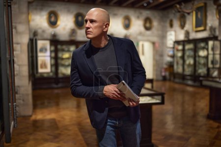 Photo for Man visitor in the historical museum looking at art object. - Royalty Free Image