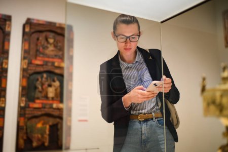 Photo for Visitor in historical museum looking at art object. - Royalty Free Image
