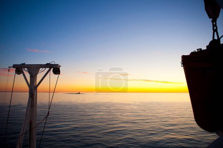 Téléchargez les photos : Fond décoratif de paysage marin avec petite île et la lumière du soleil depuis le pont de la croisière en ferry - en image libre de droit