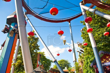 COPENHAGEN, DENMARK - JUNE 30, 2014: Chinese Lanterns, Temple Tower, Demon Roller Coaster and Vertigo rides in amusement park Tivoli Gardens in Copenhagen