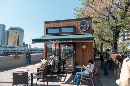 Photo for TOKYO, JAPAN - APRIL 9, 2023: People relaxing in Tully's coffee at Sumida river walk - Royalty Free Image