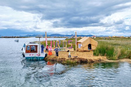 Photo for Uros, Peru - January 09, 2022: Locals in national costumes greet tourists on the floating islands on Lake Titicaca. - Royalty Free Image