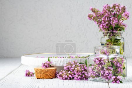 Photo for Thymus serpyllum herb in bottle.Thyme is a medicinal herb for dissolving and easier secretion of mucus.Alternative medicine concept on a white wooden table (selective focus). - Royalty Free Image