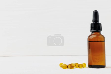 D3 vitamin in bottle and oil soft gel capsules on a white wooden table