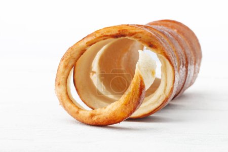 Donuts tradicionales húngaros (Kurtuskalcs), comúnmente conocido como pastel de chimenea, sobre un fondo de madera blanca desde la vista frontal, con enfoque selectivo.
