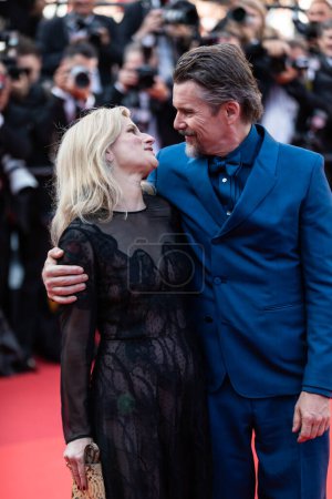 Téléchargez les photos : CANNES, FRANCE - MAY 21, 2022: US actor and writer Ethan Hawke and his wife US producer Ryan Hawke kiss as they arrive for the screening of the film "Triangle of Sadness" during the 75th edition of the Cannes Film Festival - en image libre de droit